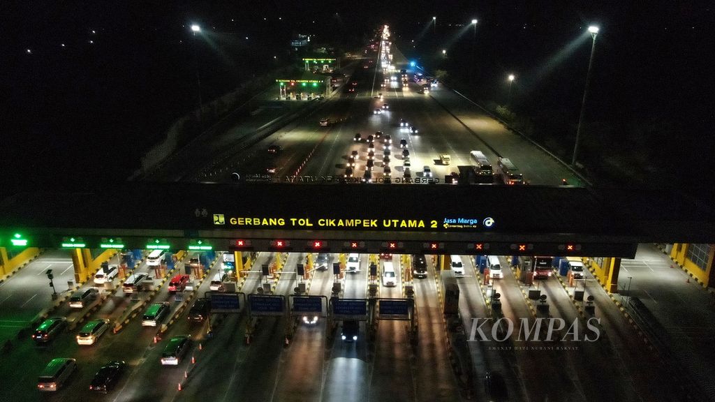Kendaraan mengantre untuk melakukan pembayaran di Gerbang Tol Cikampek Utama, Karawang, Jawa Barat, Jumat (22/12/2023). Sebanyak 37.161 kendaraan keluar dari Gerbang Tol Cikampek Utama dari arah Jakarta per pukul 20.19. 