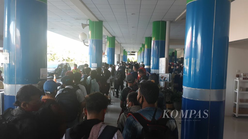 Ratusan calon penumpang pesawat mengantre untuk menunjukkan hasil tes cepat atau tes usap Covid-19 di depan terminal keberangkatan Bandara Sam Ratulangi, Manado, Sulawesi Utara, Selasa (27/10/2020).