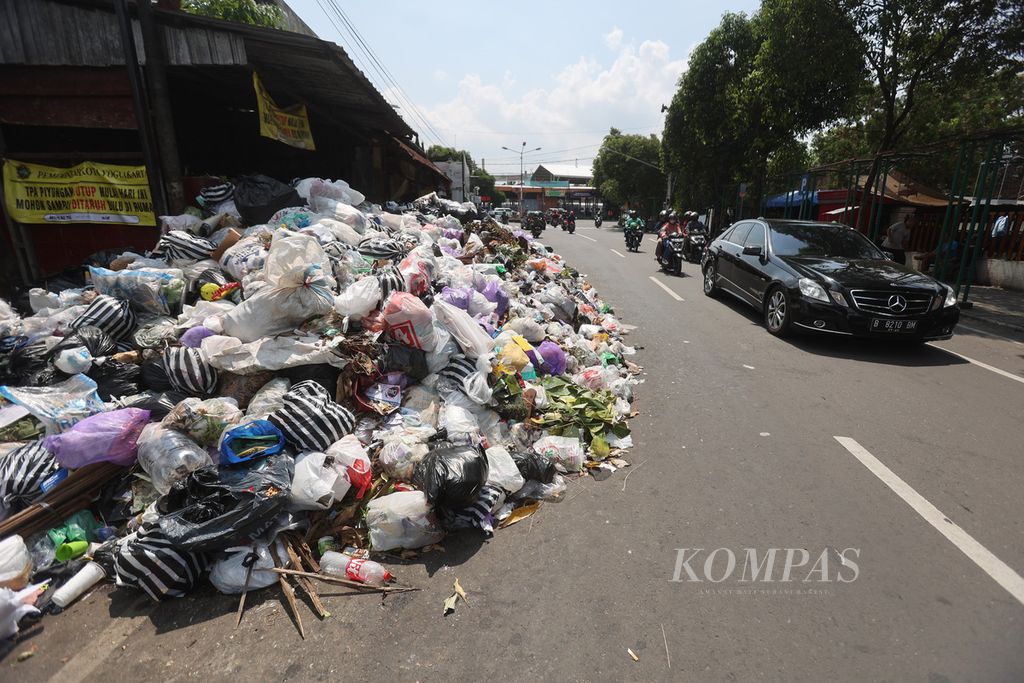 Sampah menumpuk hingga hampir memenuhi separuh ruas jalan di kawasan Lempuyangan, Yogyakarta, Selasa (10/5/2022). Tumpukan sampah terlihat di sejumlah lokasi di Yogyakarta setelah penutupan Tempat Pembuangan Sampah Terpadu (TPST) Piyungan oleh warga sejak 7 Mei 2022. 