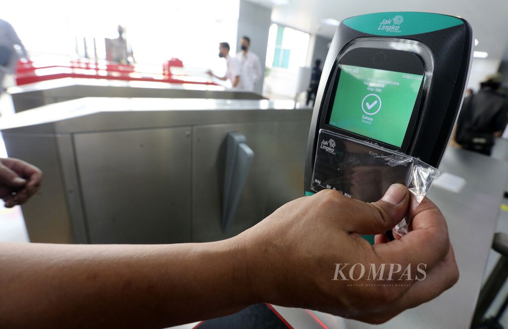 Rombongan jurnalis menempelkan kartu JakLingko pada mesin pemindai kartu JakLingko di Stasiun LRT Velodrome, Jakarta Timur saat turut dalam uji coba penggunaan kartu JakLingko untuk empat jenis moda transportasi publik, Senin (4/10/2021). 