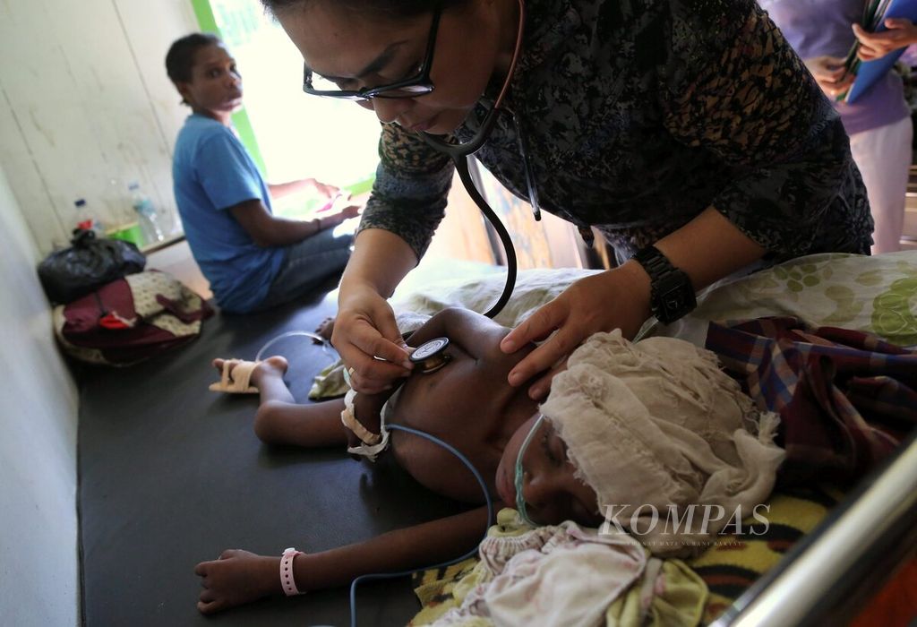Dokter Carrol Jacquelin memeriksa seorang anak yang dirawat di RSUD Agats, Papua, karena menderita campak, Januari 2018.