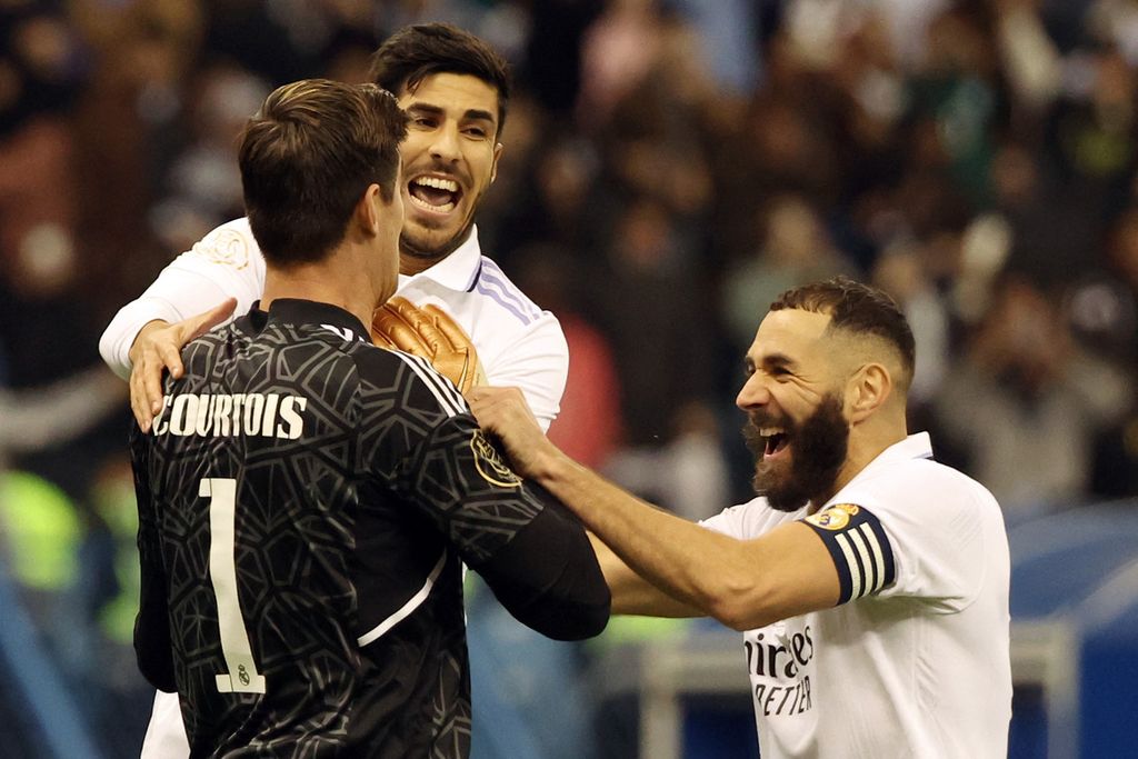 Pemain Real Madrid Karim Benzema (kanan), kiper Thibaut Courtois dan gelandang Marco Asensio (tengah) merayakan kemenangan mereka atas Valencia pada semifinal Piala Super Spanyol di Stadion Internasional King Fahd, di Riyadh, Arab Saudi, Kamis (12/1/2023) dini hari WIB. Madrid menang dengan skor 4-3 (1-1) dalam adu penalti. 