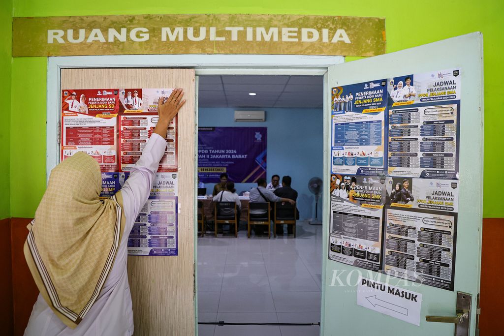 Petugas menempelkan poster informasi terkait penerimaan peserta didik baru (PPDB) di Posko Pelayanan PPDB di SMAN 78 Jakarta, Selasa (25/6/2024). 