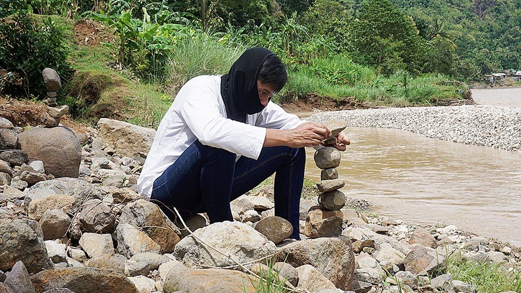  Anggota komunitas Balancing Art Indonesia, menata batu-batu tak beraturan menjadi karya seni yang indah. Ia beraksi di Sungai Oyo, Kabupaten Bantul, Yogyakarta, pada Minggu (11/3).