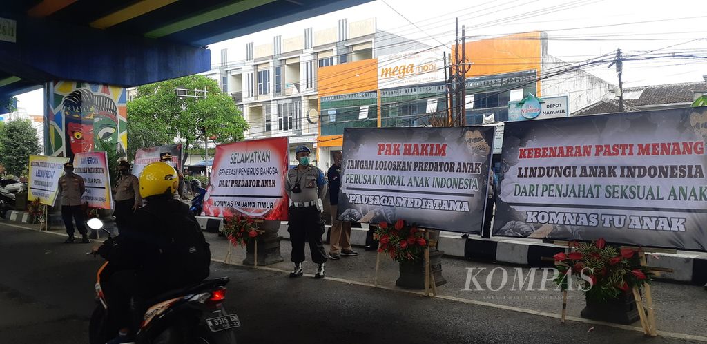 Poster dan bunga duka cita dipasang di depan Pengadilan Negeri Malang, Jawa Timur, 23 Februari 2022. Hal itu dilakukan untuk mendorong penegakan hukum kasus dugaan kekerasan seksual di Sekolah Selamat Pagi Indonesia di Kota Batu, Jatim. 