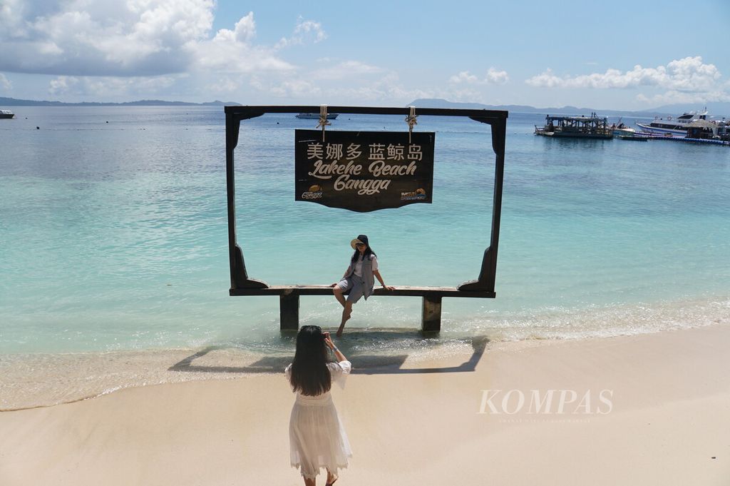 Wisatawan asal China berfoto di tepi pantai Pulau Gangga, Minahasa Utara, Sulawesi Utara, Jumat (31/1/2020).