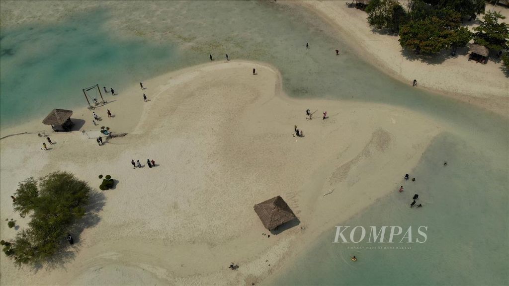 Wisatawan menikmati pasir putih di Pulau Pari, Kabupaten Kepulauan Seribu, DKI Jakarta, Minggu (4/8/2019). 