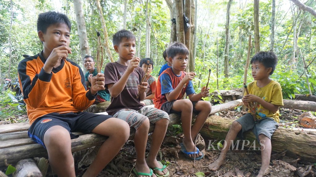 Anak-anak dari Suku Anak Dalam atau Orang Rimba tengah bermain permainan tradisional di kawasan Taman Nasional Bukit Duabelas, Desa Pematang Kabau, Kabupaten Sarolangun, Jambi, Rabu (14/6/2023).