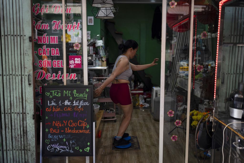 A woman exercises in her store in Ho Chi Minh City, Vietnam, on January 11, 2024.