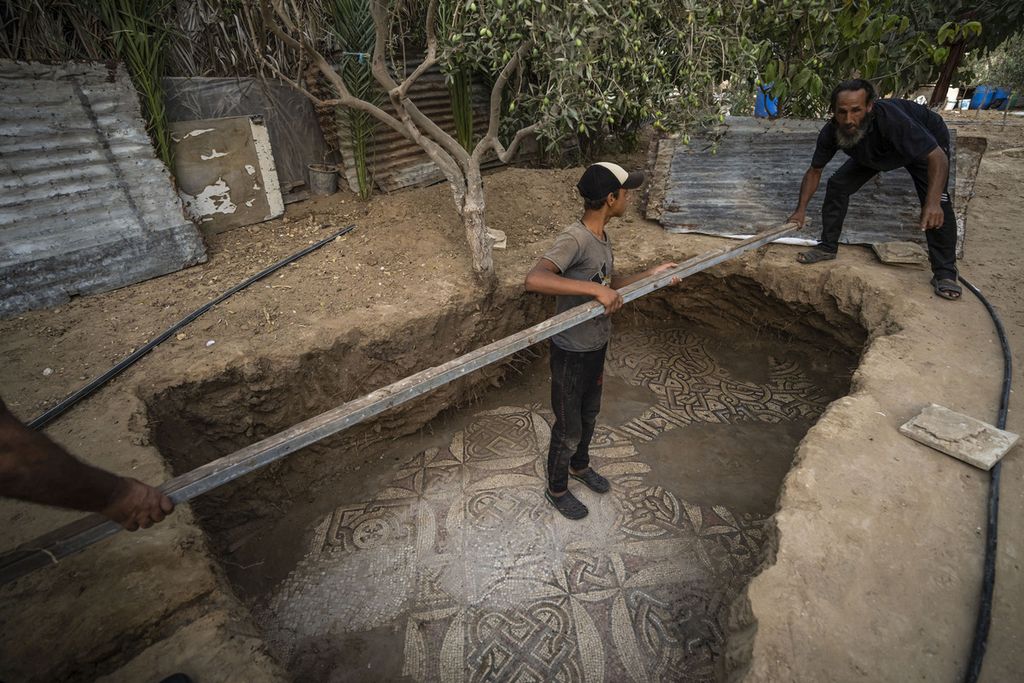 Warga Palestina membersihkan lantai mosaik era Bizantium yang ditemukan oleh seorang petani setempat di Bureij, Jalur Gaza tengah, 5 September 2022.  