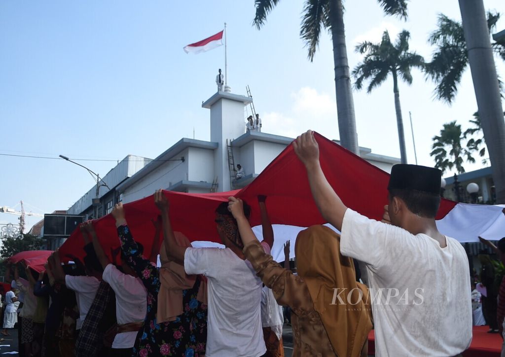 Bendera Merah Putih raksasa dibentangkan dalam aksi teatrikal sejarah peristiwa perobekan bendera Surabaya Merah Putih” di Hotel Majapahit, Surabaya, Jawa Timur, Kamis (19/9/2019). 