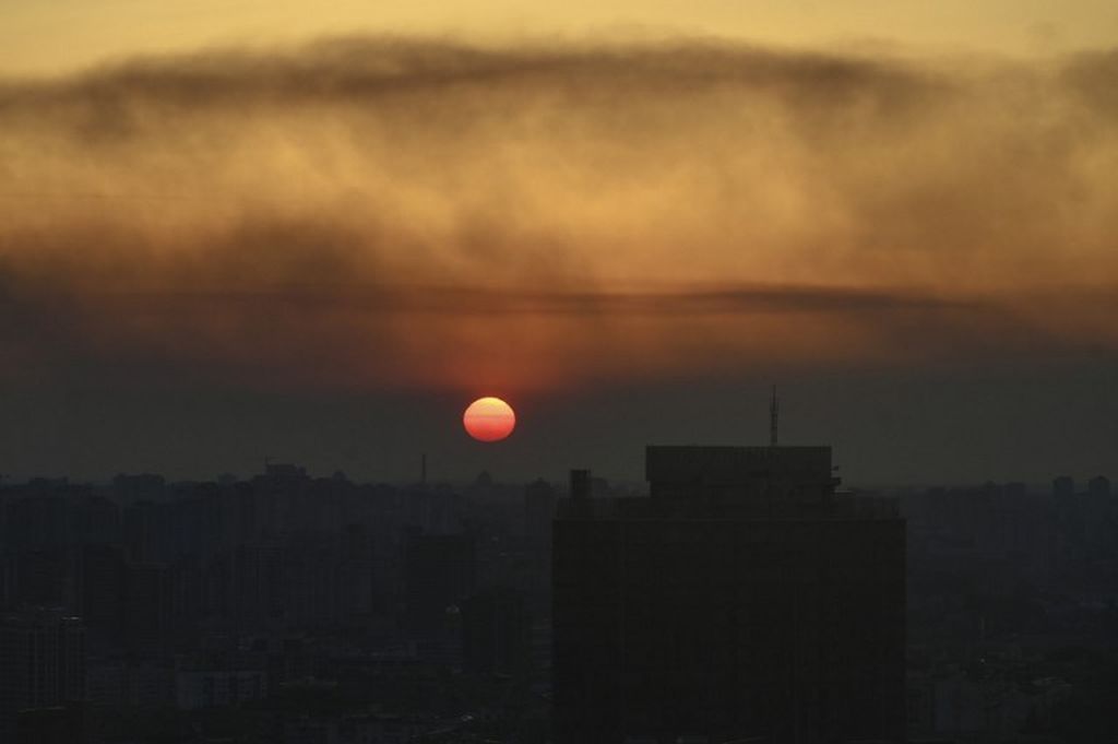 Pemandangan di Kyiv, Ukraina, saat matahari tenggelam seiring asap yang membubung dari bagian barat kota tersebut, 19 Maret 2022. 