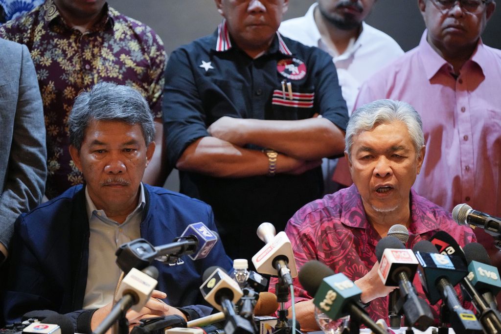 Ketua Umum UMNO sekaligus Presiden Barisan Nasional Ahmad Zahid Hamidi (duduk, kanan) menyampaikan perkembangan perundingan BN dengan Pakatan Harapan, Senin (21/22/2022) di Kuala Lumpur, Malaysia. 