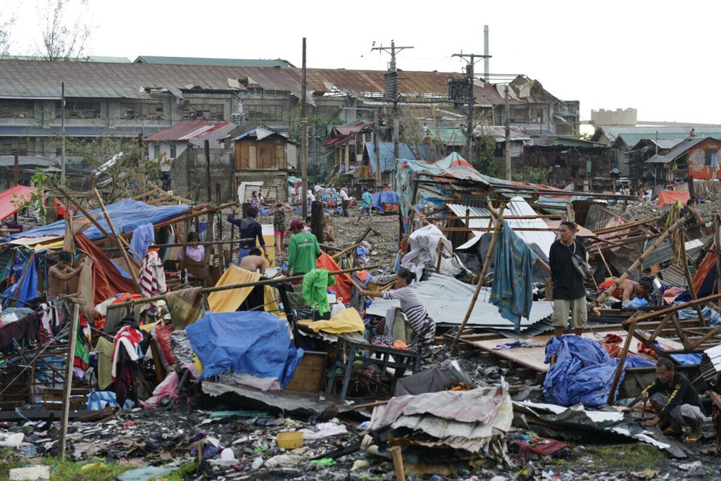Warga menyelamatkan sisa-sisa bagian rumah mereka setelah diterjang Topan Rai di Kota Cebu, Filipina, Jumat (17/12/2021). Prakiraan cuaca setempat menyebut Rai adalah topan super dengan kecepatan maksimum 195 kilometer per jam.