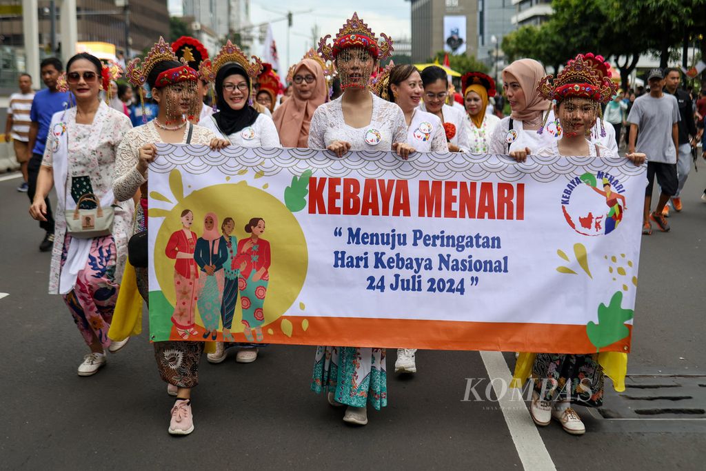 Para peserta pawai membawa spanduk pawai CFD Kartinian di Jalan MH Thamrin, Jakarta, Minggu (21/4/2024). Perempuan Berkebaya Indonesia dan Kebaya Menari menyelenggarakan pawai CFD Kartinian. 