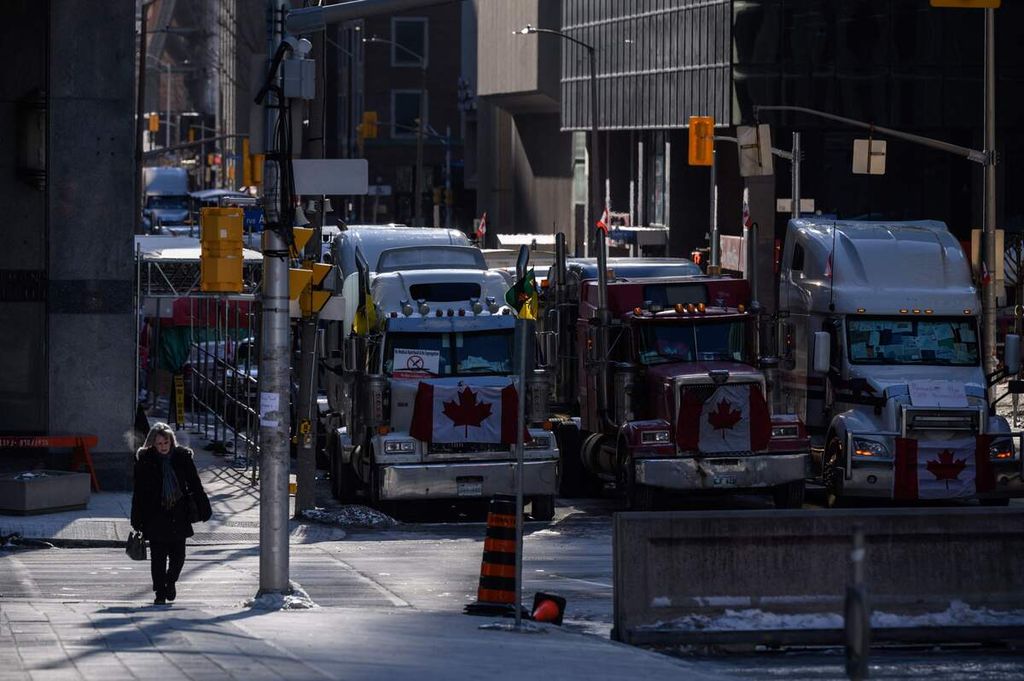 Truk-truk memblokir sebuah ruas jalan dalam unjuk rasa para sopir truk di luar gedung parlemen Kanada di Ottawa, Kanada, Senin (14/2/2022).