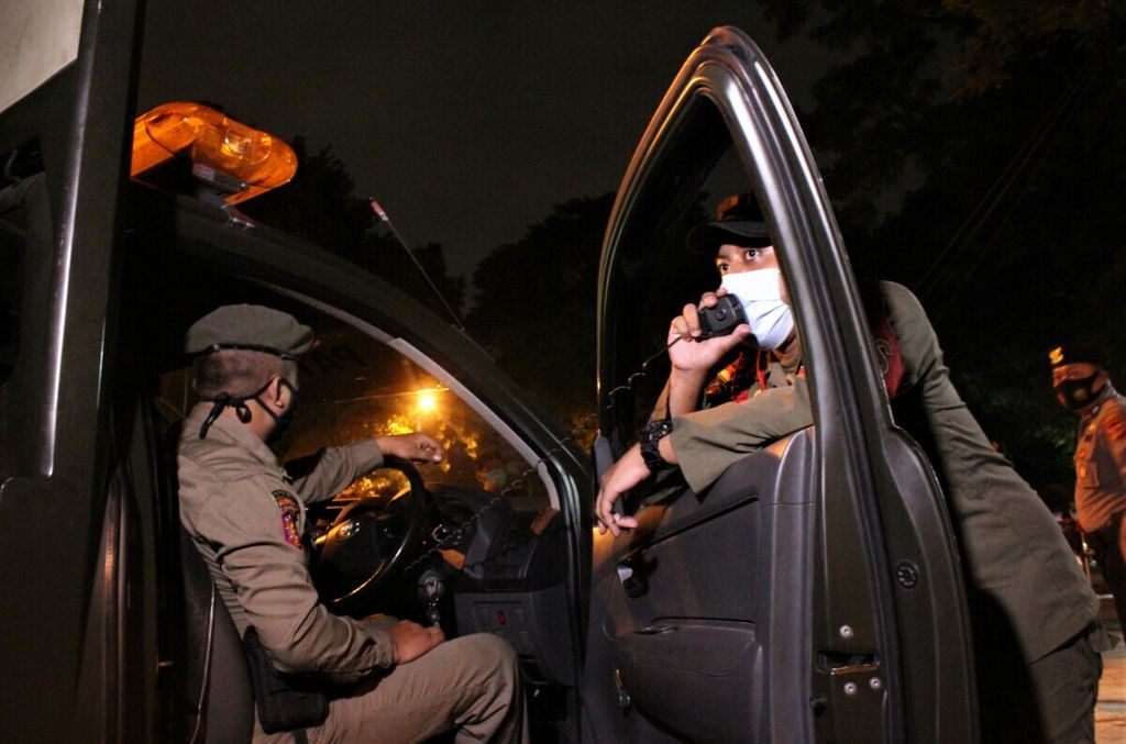 Personel Satuan Polisi Pamong Praja Kota Bandung, Jawa Barat, berpatroli di Jalan Dipati Ukur, Kota Bandung, Jawa Barat, Kamis (3/12/2020) malam. 