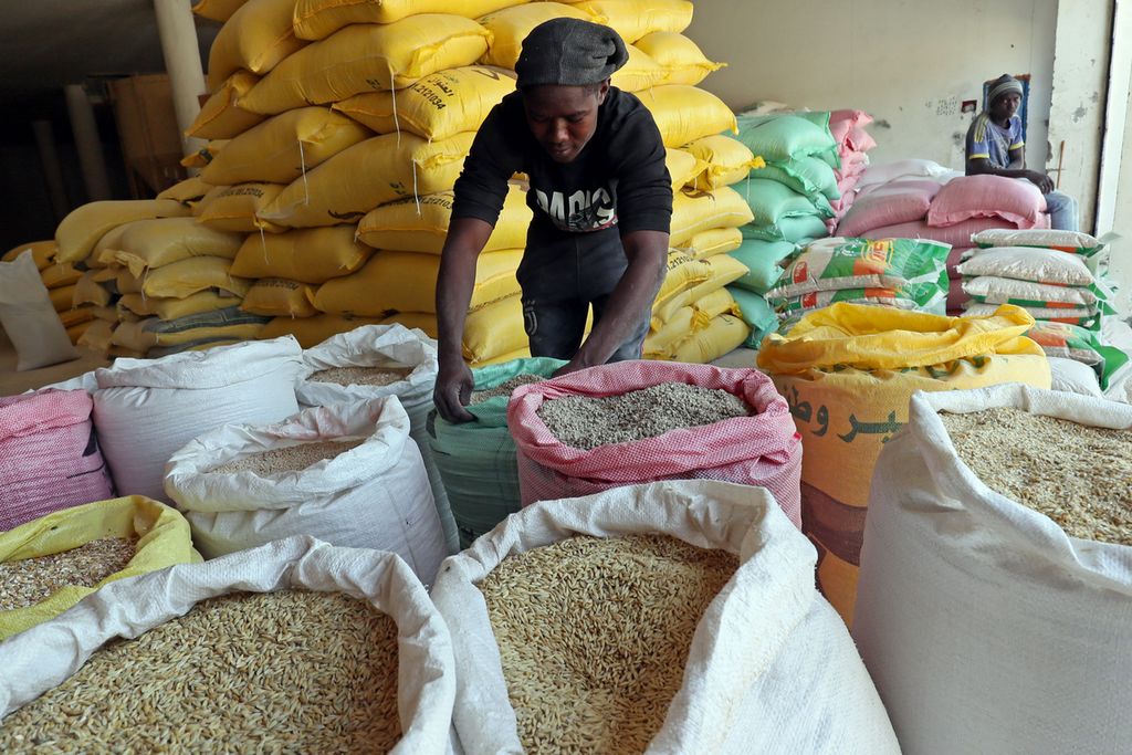 Seorang pekerja mengatur kantong-kantong gandum di pasar biji-bijian di ibu kota Libya, Tripoli, pada 22 Juli 2023.