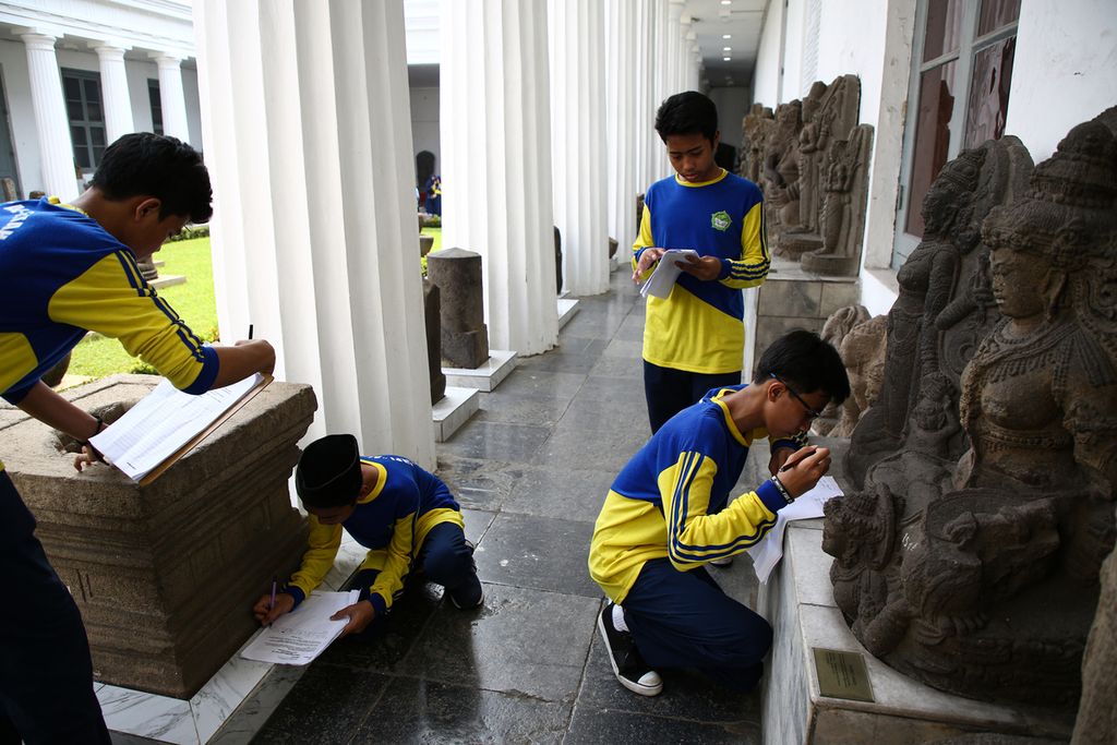Siswa SMP Islam Al Fatah, Penjaringan, Jakarta Utara mengerjakan tugas sekolah dalam studi tur ke Museum Nasional, Jakarta Pusat, Sabtu (14/3/2020). 