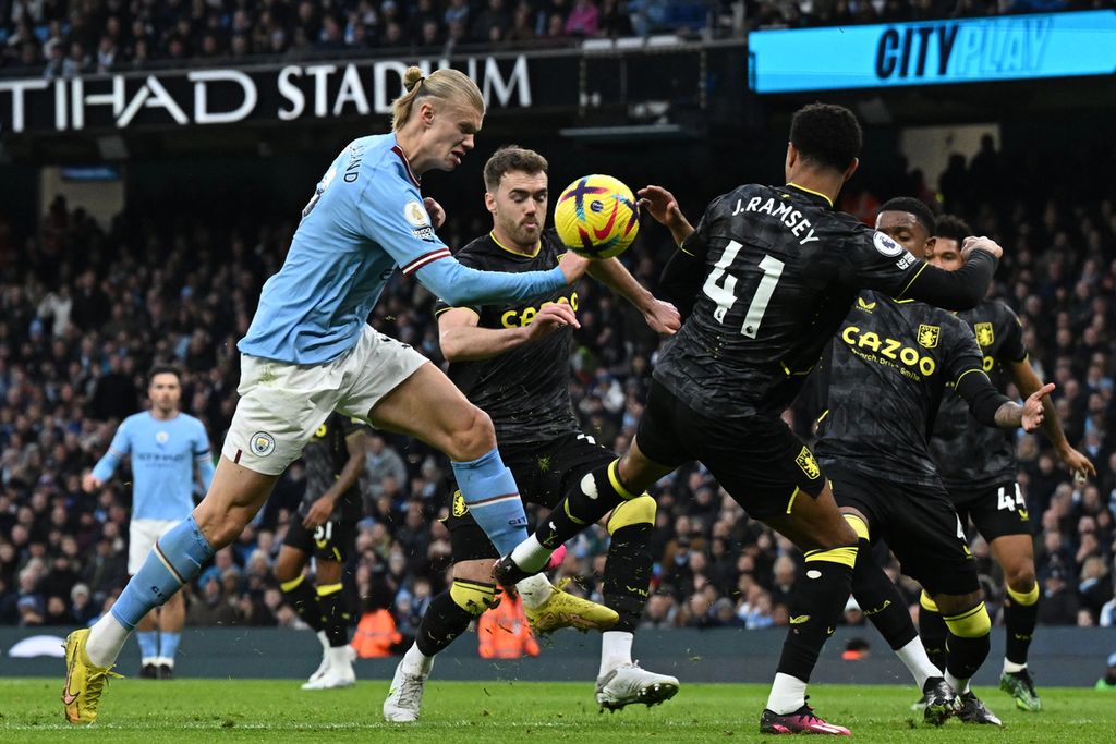 Striker Manchester City Erling Haaland (kiri) melakukan tembakan saat pertandingan sepak bola Liga Utama Inggris antara Manchester City dan Aston Villa di Stadion Etihad di Manchester, Inggris, Senin (13/2/2023) dini hari WIB. 