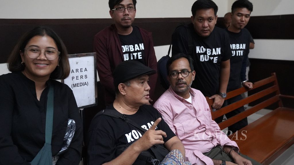 Paguyuban Korban UU ITE (PAKU ITE) melakukan aksi solidaritas mendukung Haris Azhar (ketiga dari kanan) dan Fatia Maulidiyanti (kiri) di Pengadilan Negeri Jakarta Timur, Senin (22/5/2023). 