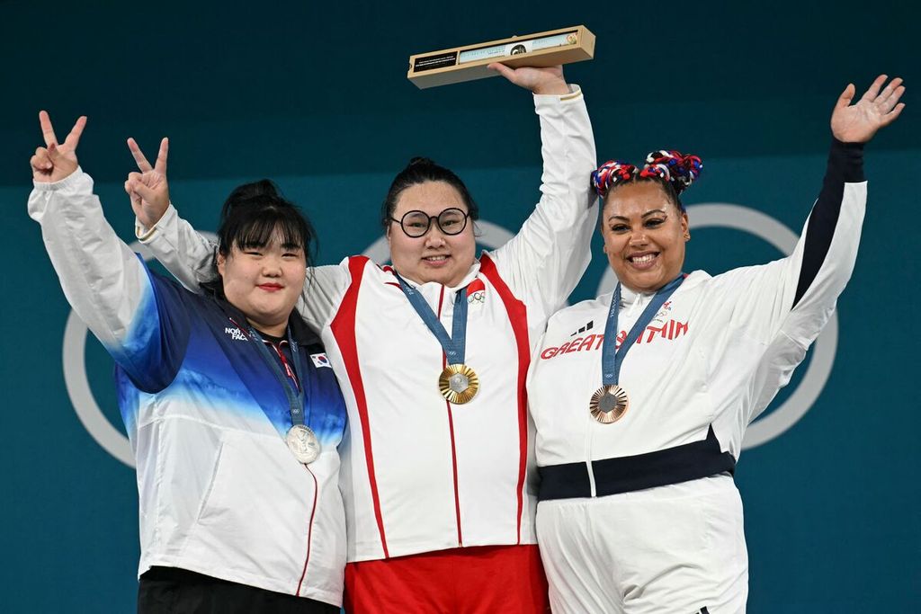 Lifter China, Li Wenwen (tengah) dan para peraih medali angkat besi kelas +81 kilogram Olimpiade Paris 2024 memamerkan medali mereka di Paris, Minggu (11/8/2024). (Dari kiri ke kanan) peraih perak lifter Korea Selatan, Park Hyejeong; peraih emas Li Wenwen; dan peraih perunggu dari Inggris, Emily Campbell. 