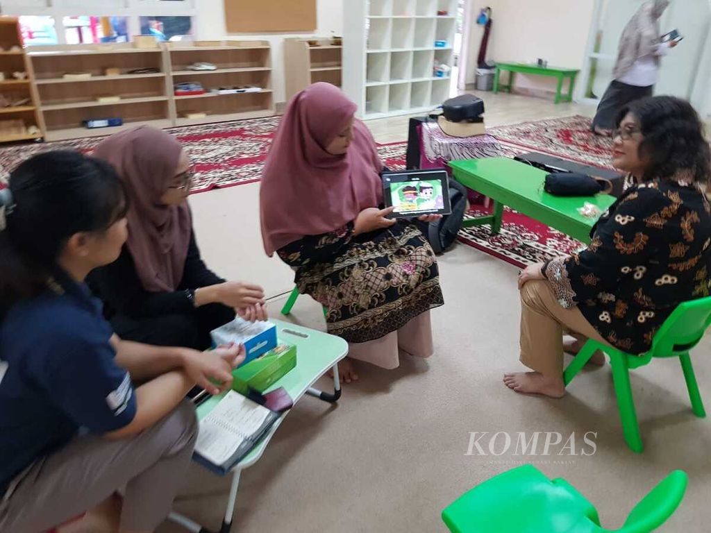 Fatimah Aidid, guru dari TK AIUEO Bekasi, menjajal tablet berisi aplikasi pembelajaran pada saat mentoring Sekolah Enuma di TK Angkasa 1 Halim Perdanakusuma, Jakarta Timur, Minggu (15/7/2023).