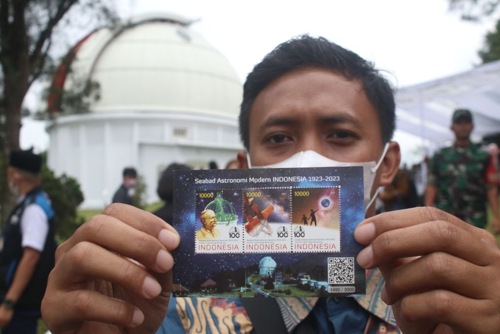 Salah satu peserta menunjukkan prangko Seabad Astronomi Modern Indonesia 1923-2023 di depan kopel, ikon dari Observatorium Bosscha, di Kecamatan Lembang, Kabupaten Bandung Barat, Jawa Barat, Senin (30/1/2023). Prangko ini hadir dalam peringatan 100 tahun Observatorium Bosscha.