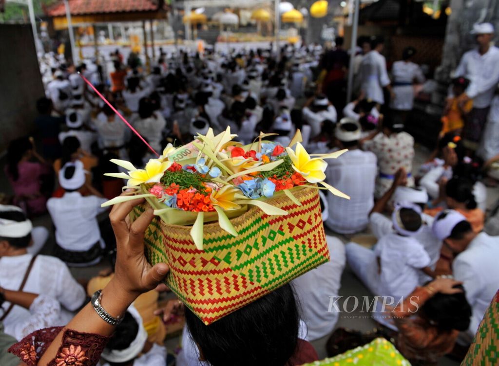 Umat Hindu membawa sesaji datang ke Pura Sakenan di Pulau Serangan, Denpasar, Bali, untuk melaksanakan sembahyang dalam rangkaian perayaan Kuningan, Minggu (7/4/2013). Selain saat upacara keagamaan, membuat sesaji dan meletakkannya di tempat-tempat tertentu menjadi ritual harian masyarakat di Bali. 