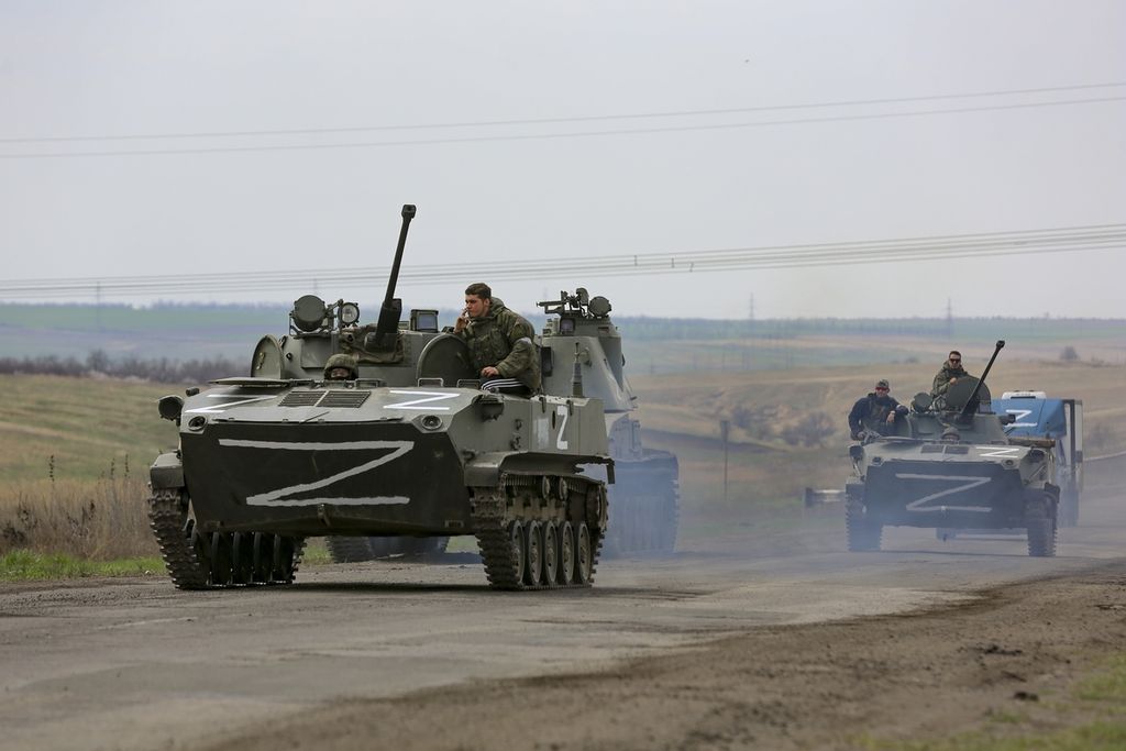  Kendaraan militer Rusia melintasi area yang dikuasai oleh kelompok separatis dukungan Kremlin di dekat kota Mariupol, Ukraina, Senin (18/4/2022). Gagal merebut Kiev, militer Rusia mengalihkan fokus untuk merebut wilayah timur dan selatan Ukraina. 