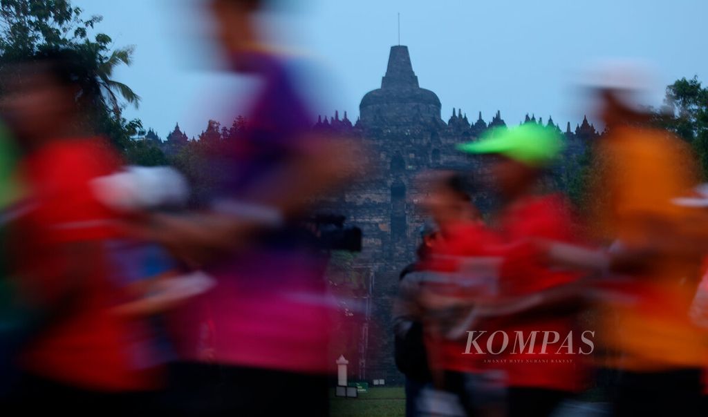 Para pelari kategori Bank Jateng Tilik Candi berlari dengan latar belakang kemegahan Candi Borobudur dalam lomba Borobudur Marathon 2022 Powered by Bank Jateng di Kabupaten Magelang, Jawa Tengah, Minggu (13/11/2022). 