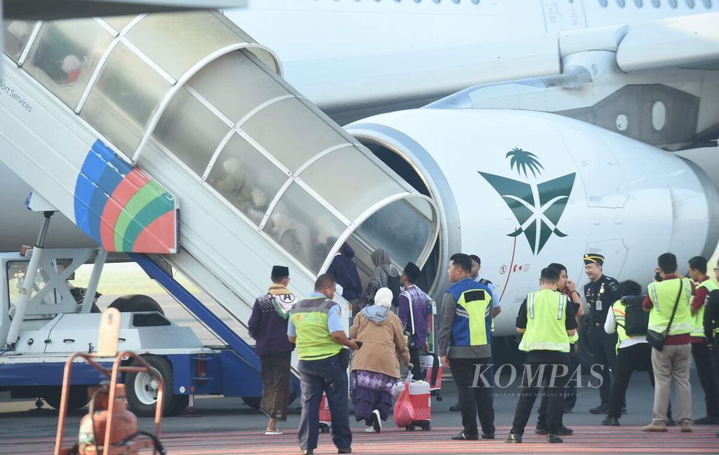 Calon jemaah haji Kelompok Terbang 2 Embarkasi Surabaya yang berasal dari Kabupaten Bojonegoro memasuki pesawat di Bandara Juanda Surabaya di Sidoarjo, Jawa Timur, Minggu (12/5/2024). 