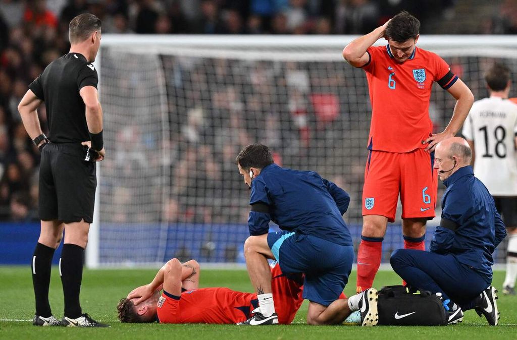 John Stones, bek timnas Inggris, terbaring dan mendapatkan perawatan medis saat menghadapi Jerman pada laga Liga Nasional Eropa di Stadion Wembley, London, Inggris, 26 September 2022.