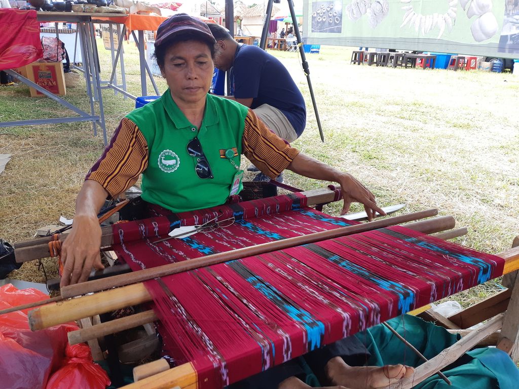 Seorang ibu dari Pulau Lembata mendemonstrasikan cara membuat tenun ikat dalam pameran Pesta Rakyat yang diadakan untuk memeriahkan KTT ASEAN di Labuan Bajo, Kabupaten Manggarai Barat, Nusa Tenggara Timur, Minggu (7/5/2023). Tak kebagian stan pameran dari panitia, rombongan petenun menyewa tenda. 