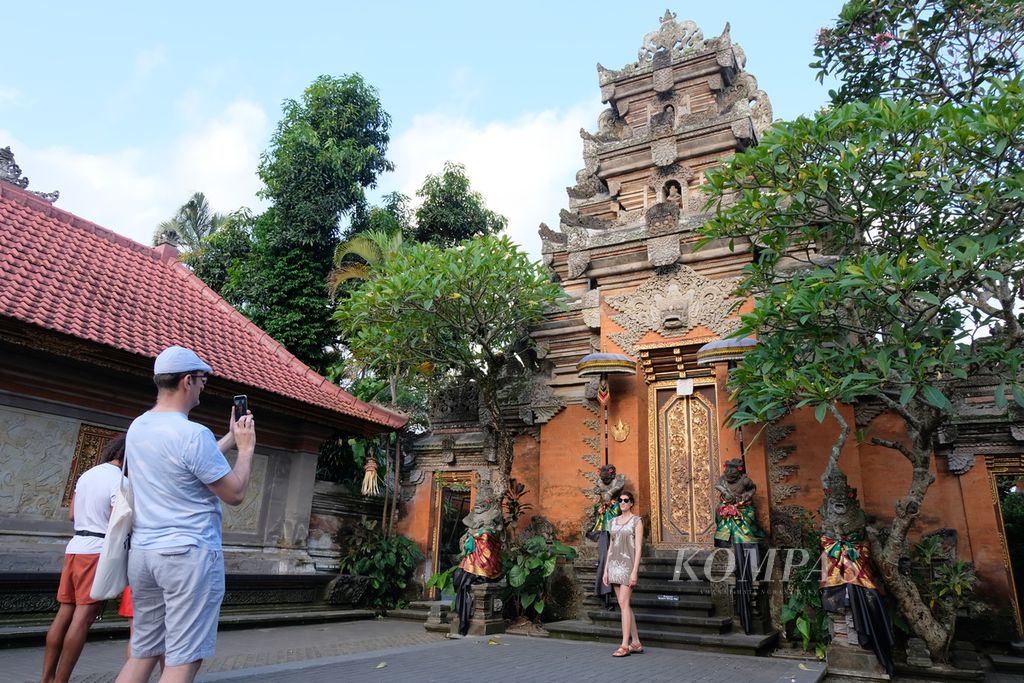 Sejumlah wisatawan berfoto di kawasan Puri Ubud yang terletak di Ubud, Kabupaten Gianyar, Bali, Sabtu (4/5/2024). Ubud menjadi destinasi pariwisata kebugaran (<i>wellness</i>) yang menarik wisatawan mancanegara dan lokal.