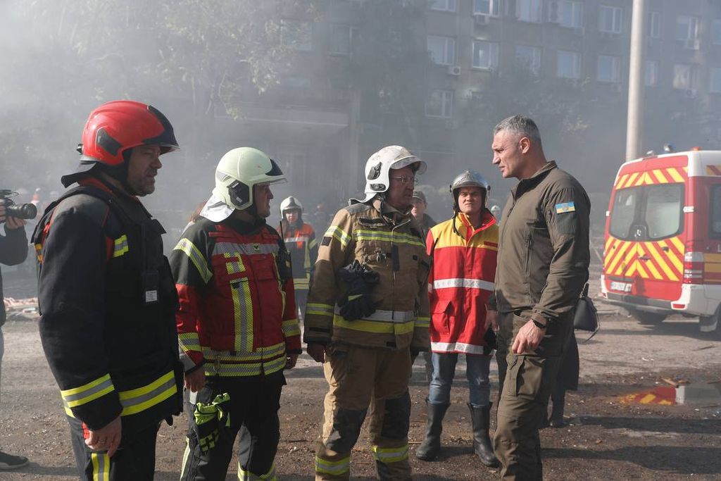 Petugas gawat darurat Kyiv, Ukraina, membahas proses evakuasi korban di salah satu gedung yang meledak pada Senin (17/10/2022) dini hari. Gedung itu salah satu sasaran pesawat nirawak berpeledak yang diarahkan Rusia ke sejumlah kota di Ukraina.