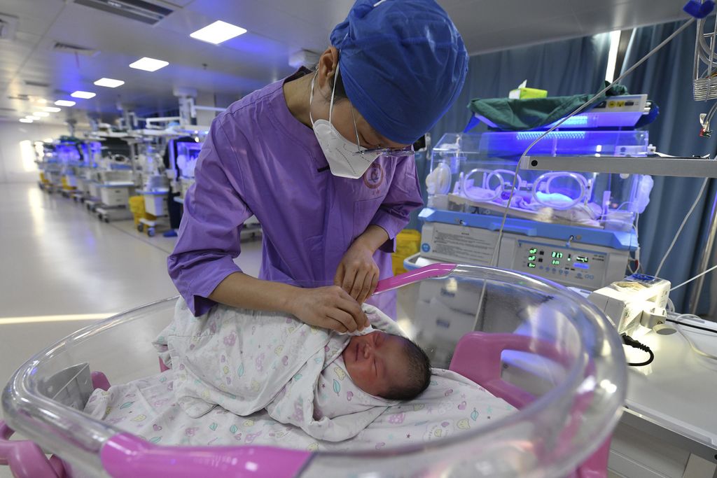 Seorang perawat tengah merawat seorang bayi yang baru lahir di rumah sakit bersalin di Fuyang pada Selasa (17/1/2023).