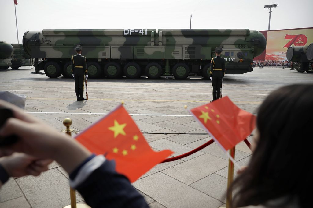 fFoto arsip - Penonton mengibarkan bendera China saat kendaraan militer yang membawa rudal balistik nuklir DF-41 meluncur selama parade untuk memperingati 70 tahun berdirinya Partai Komunis China di Beijing, China, pada 1 Oktober 2019.