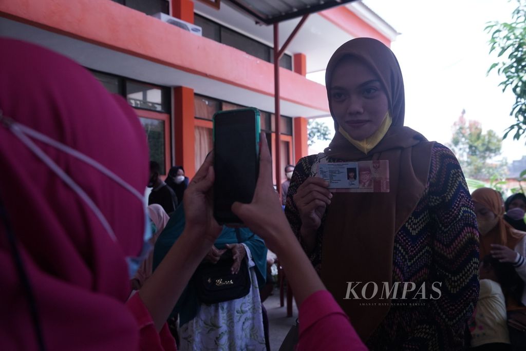 Petugas Kantor Pos Kendari memotret warga penerima BLT minyak goreng di Kendari, Sulawesi Tenggara, Rabu (13/4/2022).