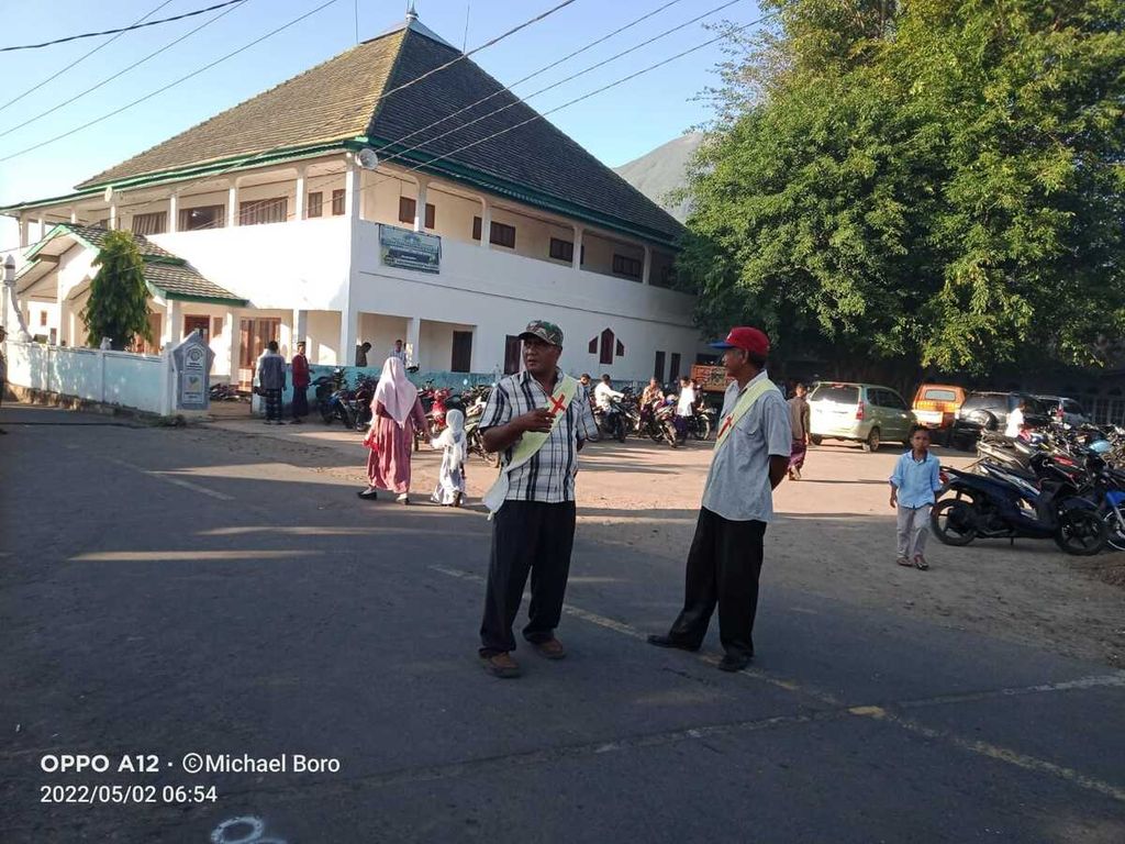 Umat Katolik yang mengenakan selempang bermotif salib ikut menjaga jalannya shalat Idul Fitri di Kampung Witihama, Pulau Adonara, Kabupaten Flores Timur, Nusa Tenggara Timur, pada Senin (3/5/2022).