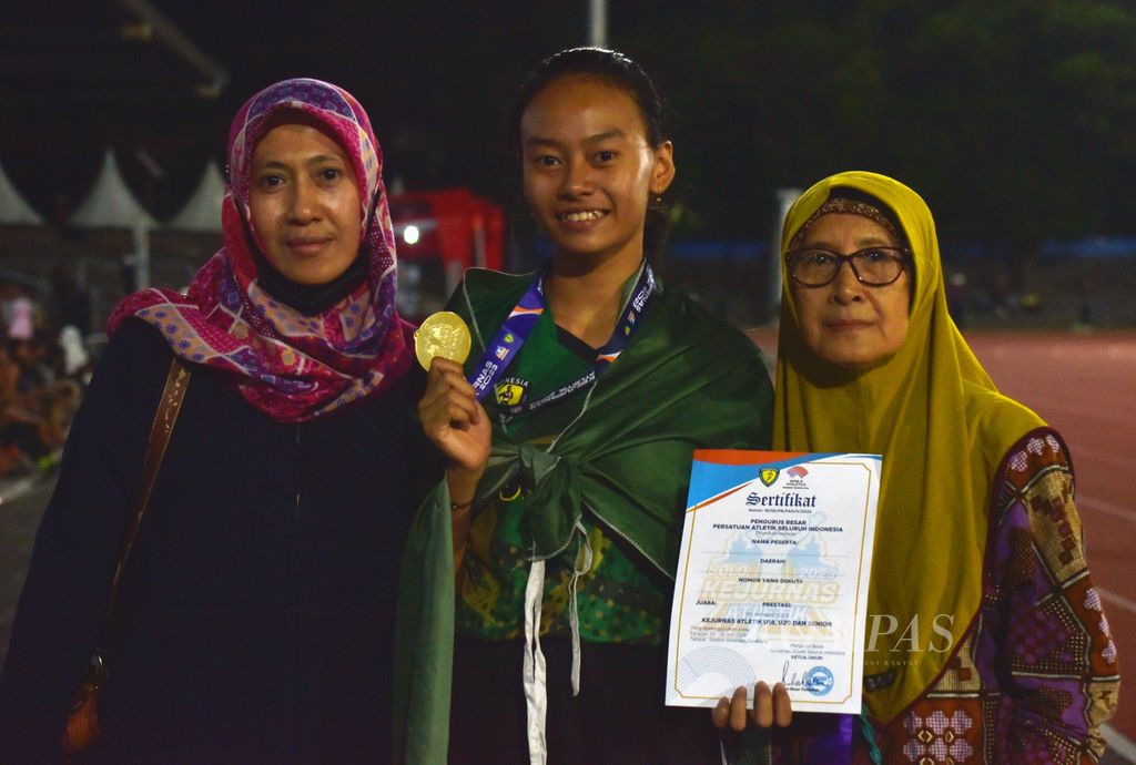 Pelari remaja atau U-18 putri asal Jawa Timur, Hoshi Fatihah A Hartono (tengah), berpose dengan ibu dan neneknya seusai meraih medali emas lari 100 meter putri Kejuaraan Nasional Atletik 2023 di Stadion Sriwedari, Solo, Jawa Tengah, Kamis (22/6/2023). Hoshi finis pertama dengan waktu 12,67 detik. 