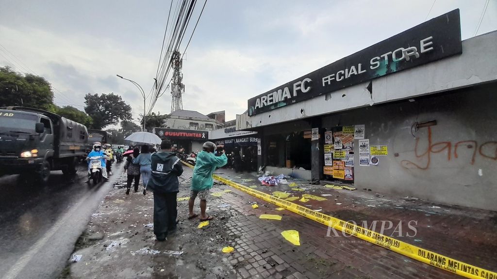 Warga mengabadikan kondisi kantor Arema FC di Jalan Mayjen Panjaitan, Kota Malang, Jawa Timur, yang rusak setelah unjuk rasa oleh yang kelompok suporter yang mengatasnamakan diri "Arek Malang Bersatu", Minggu (29/1/2023)