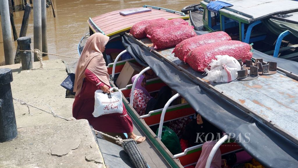 Warga menaiki kapal tujuan Tamban Catur, Kabupaten Kapuas, Kalimantan Tengah, di Dermaga Pasar Baru, Kota Banjarmasin, Kalimantan Selatan, Senin (29/1/2024). 
