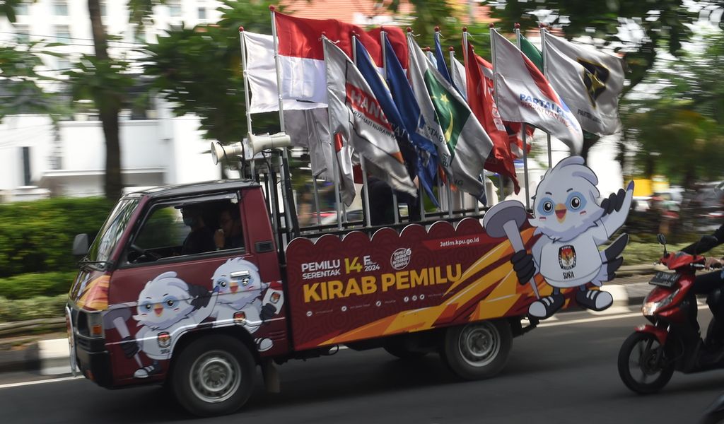 Mobil bak terbuka mengangkut bendera partai politik peserta pemilu saat Kirab Pemilu 2024 melintas di Jalan Darmo, Surabaya, Jawa timur, Selasa (9/5/2023). 