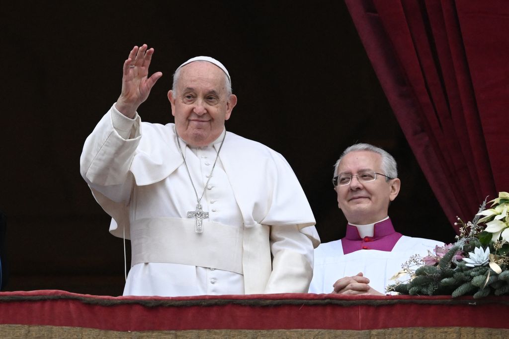 Paus Fransiskus berdiri di balkon Basilika Santo Petrus untuk menyampaikan pemberkatan Natal <i>Urbi et Orbi</i> di Lapangan Santo Petrus di Vatikan, Senin (25/12/2023).