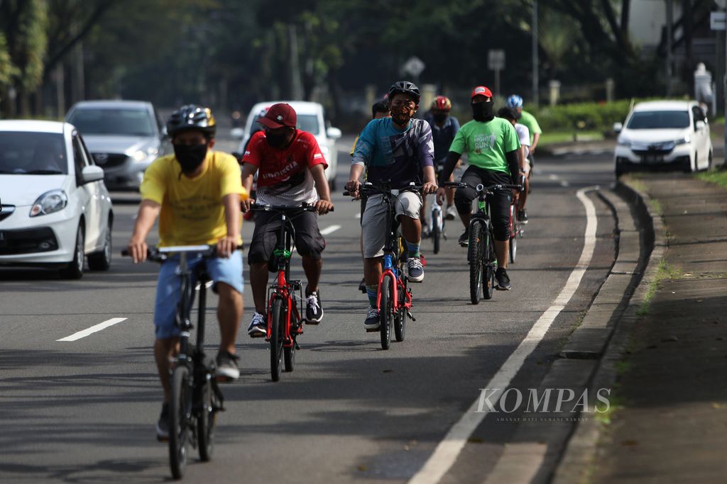 Pesepeda dengan mengenakan masker melintas di Jalan Letnan Sutopo, Tangerang Selatan, Minggu (31/5/2020). Berbagai aktivitas dilakukan warga untuk menjaga imunitas tubuh agar bisa terhindar dari Covid-19, salah satunya dengan olahraga bersepeda. 