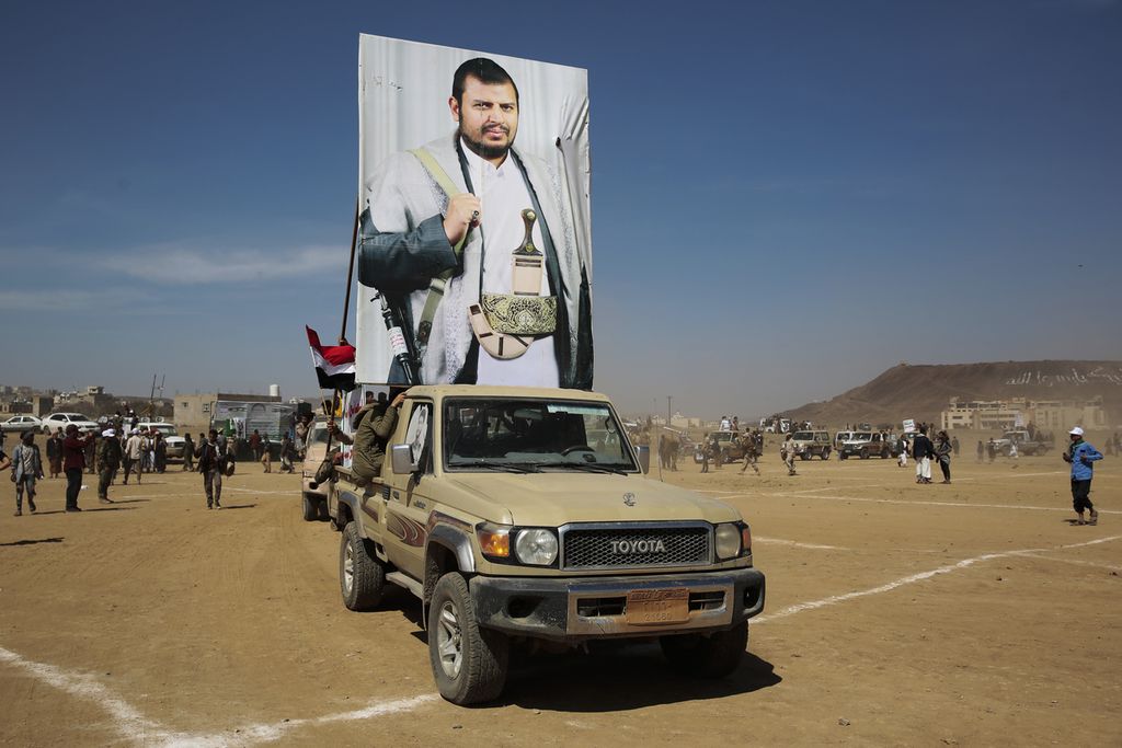 Anggota kelompok Houthi memasang poster pemimpin mereka, Abdel Malek al Houthi, saat unjuk rasa mendukung Palestina di Jalur Gaza dan menentang serangan AS di Yaman, di kota Sana’a, Yaman, 29 Januari 2024. 