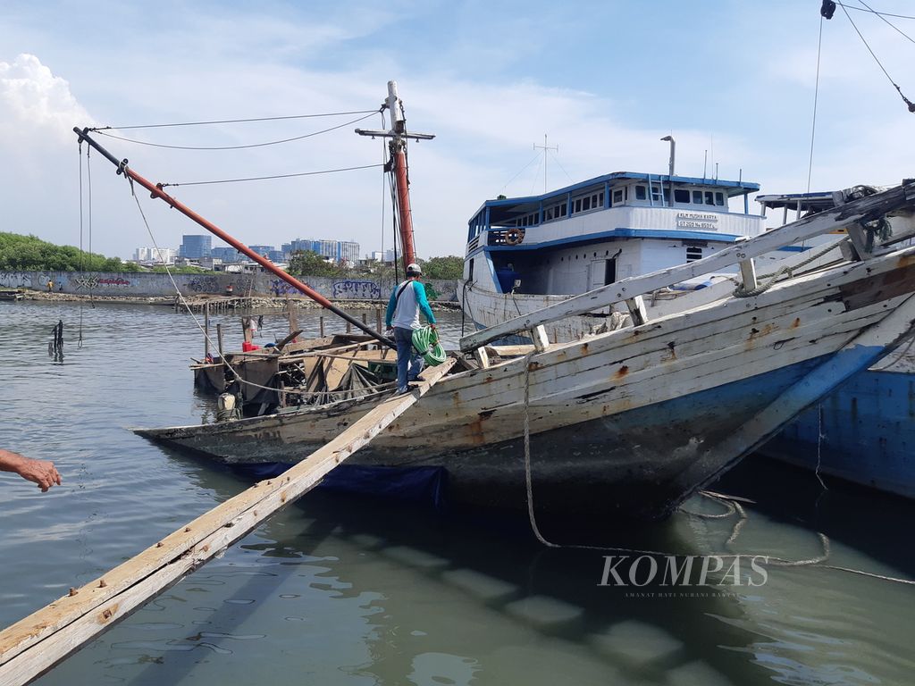 Sejumlah pekerja meninjau kapal pinisi yang karam di Pelabuhan Sunda Kelapa, pada Selasa (11/7/2023) siang. Kapal itu karam akibat terbakar pada awal Mei 2023.