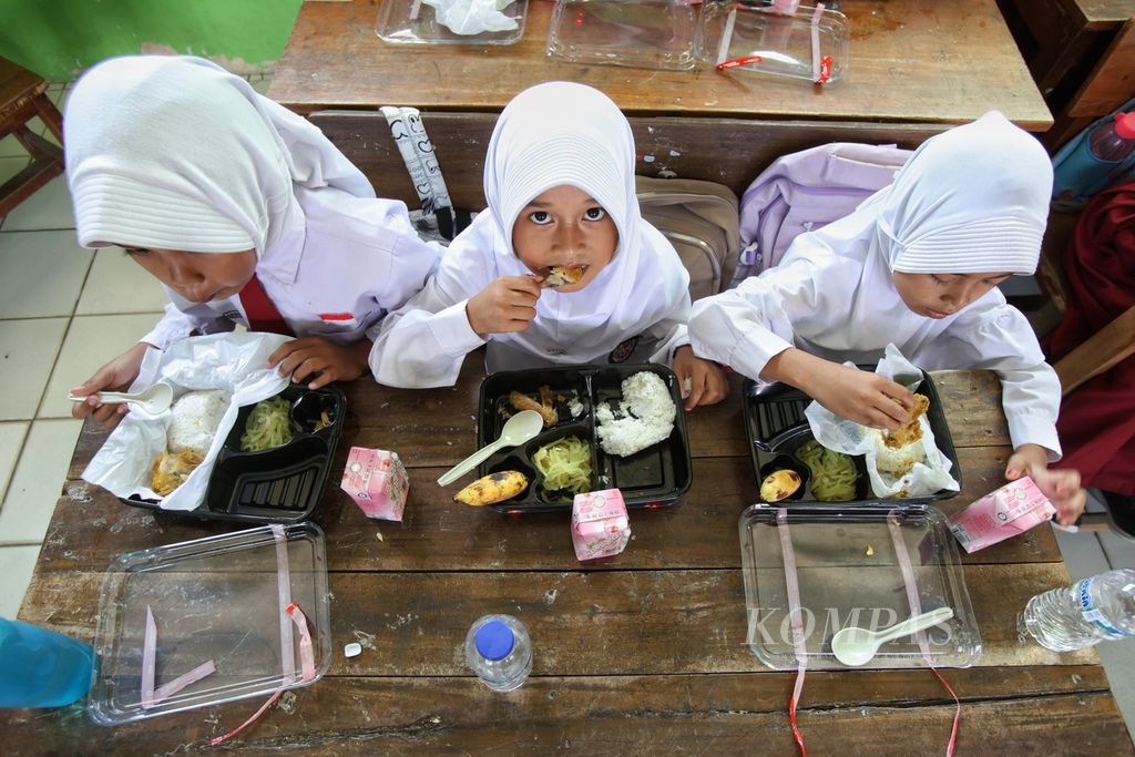 Tiga siswi makan bersama dalam uji coba makan bergizi gratis di SDN Sentul 02 Kabupaten Bogor, Jawa Barat, Selasa (23/7/2024).  