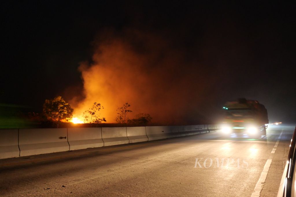 Tampak kebakaran lahan terjadi di pinggir jalan di seberang jalur Kilometer 193 Tol Lampung-Sumatera Selatan di Bujung Sari Marga, Kecamatan Pagar Dewa, Kabupaten Tulang Bawang Barat, Provinsi Lampung, Senin (23/10/2023). 